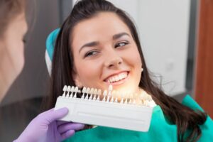 A dentist determining a patient’s tooth shades.