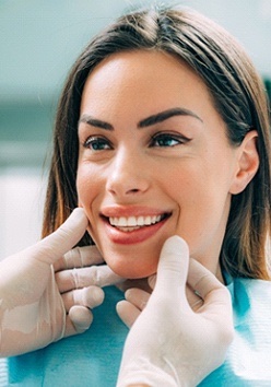 A dentist examining a woman’s smile in order to create a treatment plan for a smile makeover