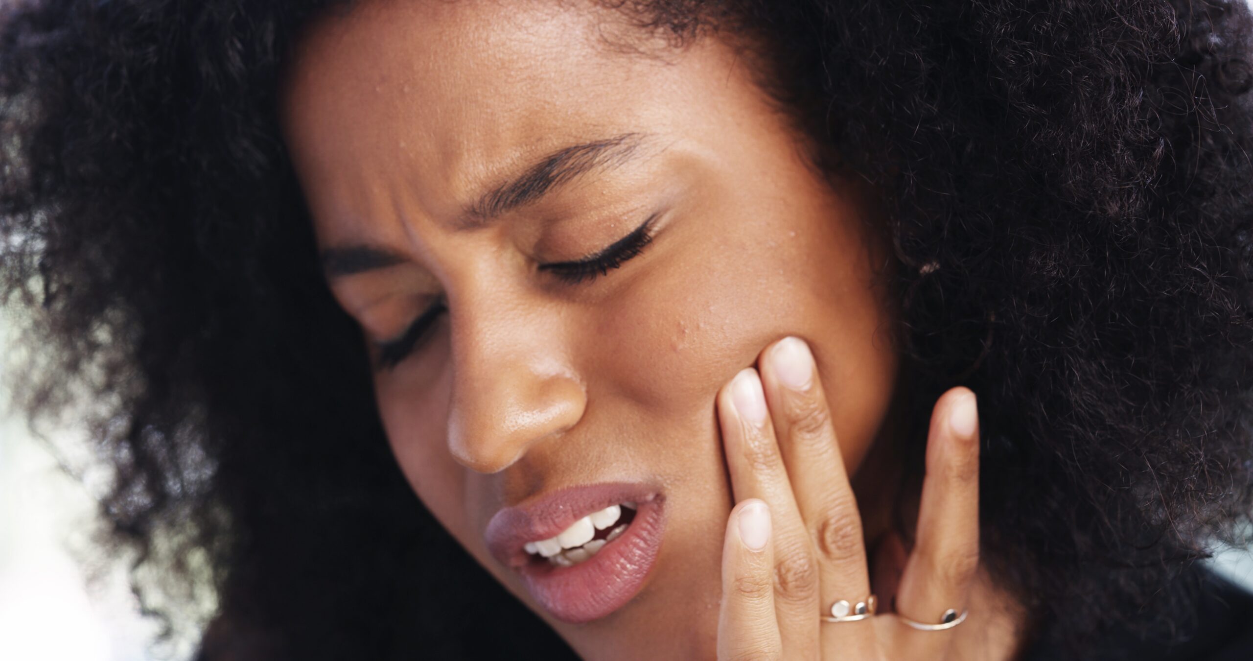 young woman suffering from jaw pain related to TMJ