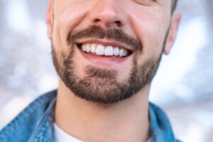 closeup of a bearded man with a white smile