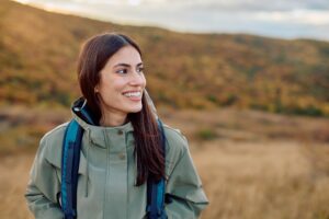 happy woman hiking outdoors, perfect white teeth