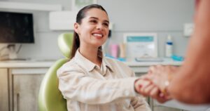 calm woman shaking hands with a dentist, modern dental practice